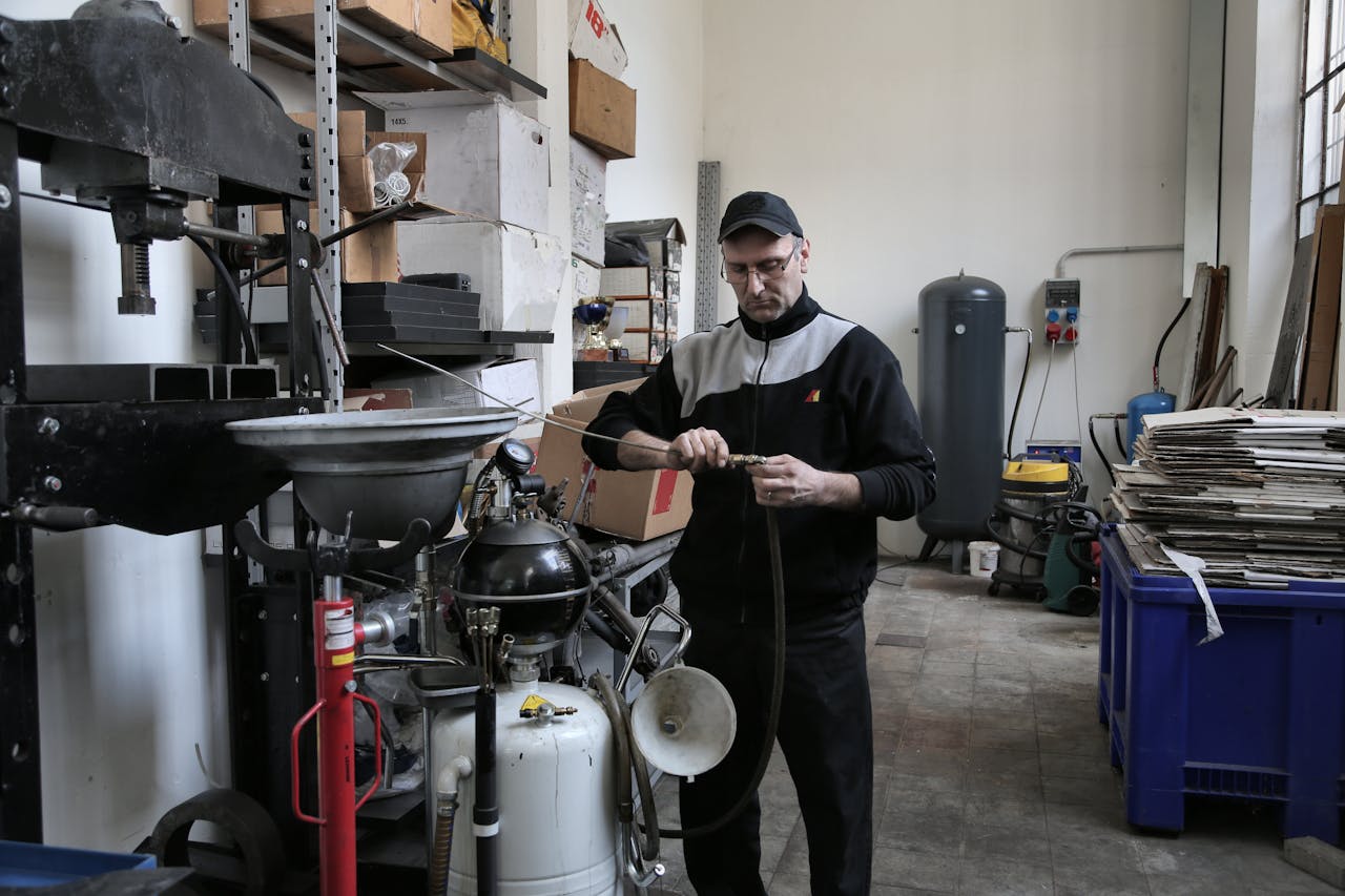Technician inspecting machinery in an industrial indoor workshop setting.